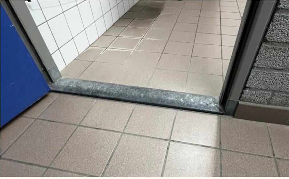 Foto van een lage maar bestaande drempel in de kleedkamer.